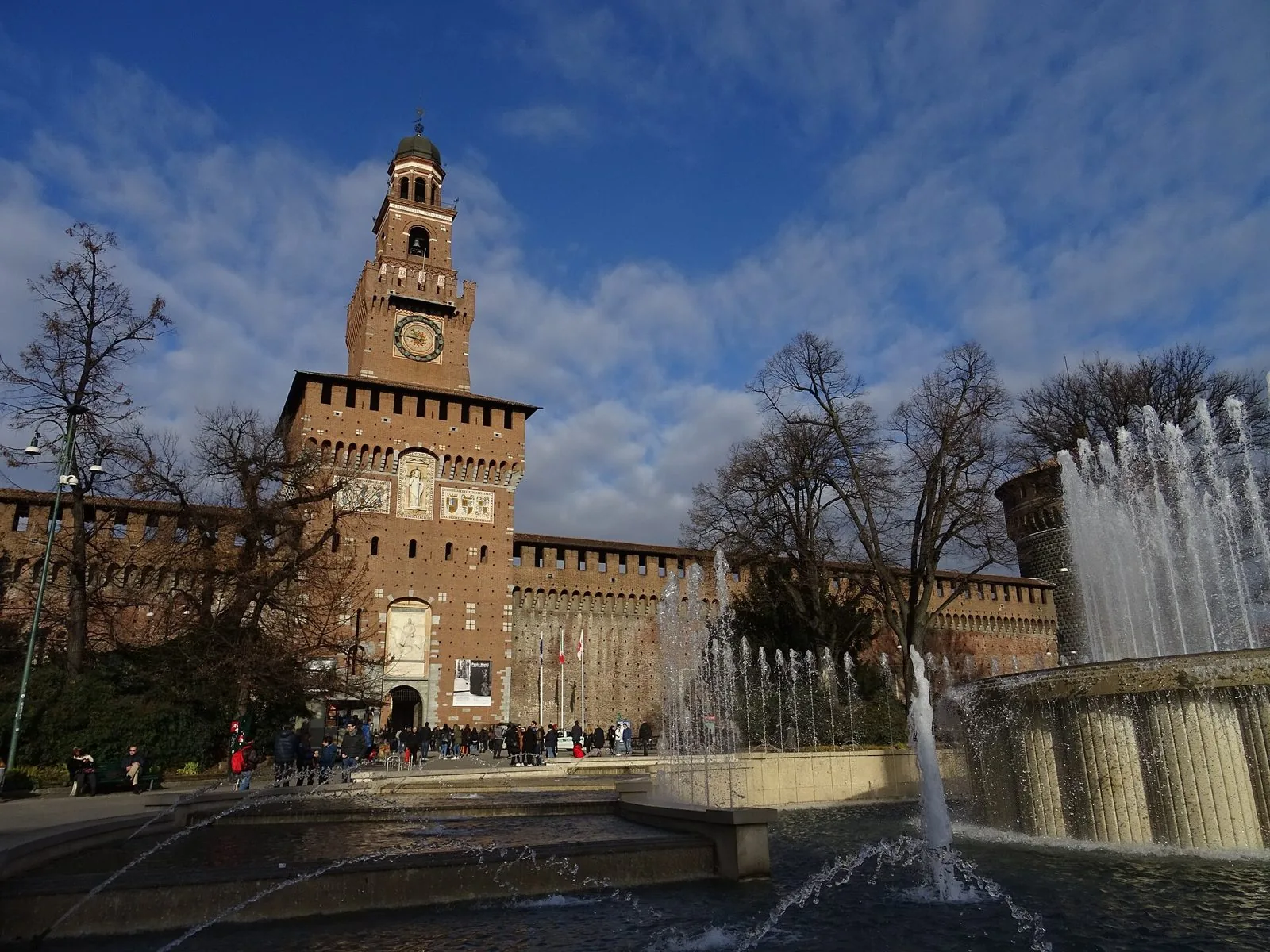 Torre del Filarete del Castello Sforzesco con la fontana in primo piano e il cielo azzurro