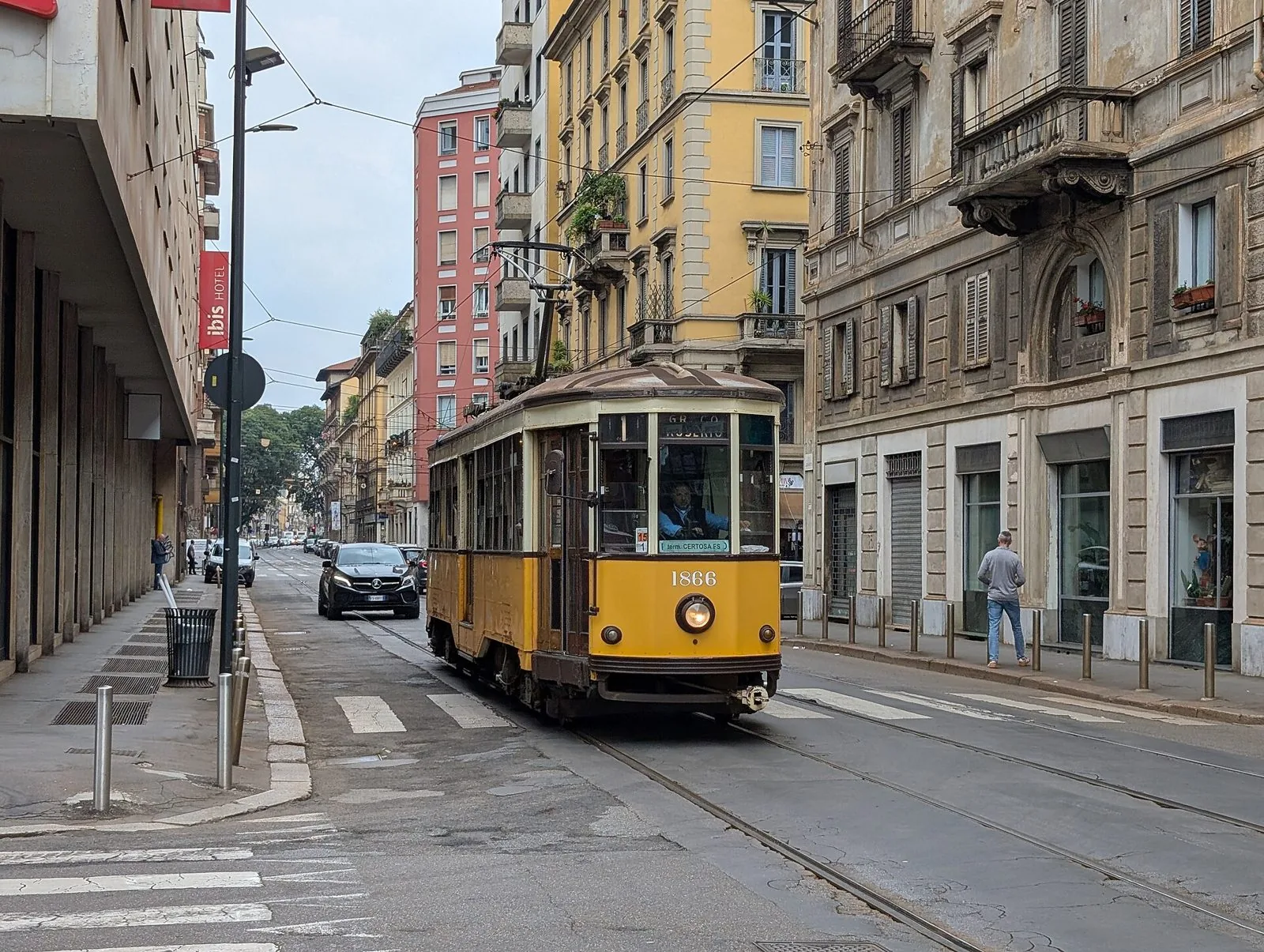 Tram storico milanese serie 1500 color arancio in una via del centro di Milano